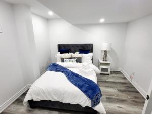 米西索加Feel Like Home/ Bs Mississauga的一间卧室配有一张带蓝白色床单的大床