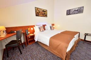 默朗强烈酒店的配有一张床和一张书桌的酒店客房