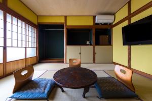 Mitsuhama三津ミーツ的配有桌椅和电视的客房
