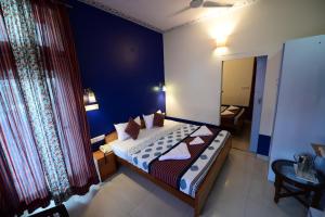 斋浦尔Chitra Katha - A Story Per Stay的一间卧室配有一张蓝色墙壁的床