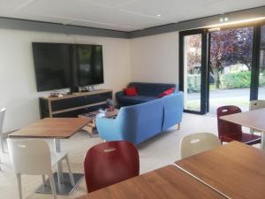 苏瓦松Kyriad Direct Soissons的客厅配有蓝色的沙发和电视