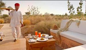 山姆Hilton Jaisalmer Desert camp的一个人站在沙发前