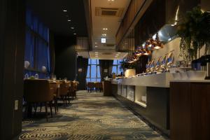 清州市J One Hotel Cheongju的餐厅设有酒吧,配有桌椅