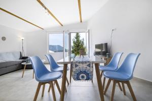 梅加尼西岛Scorpios View Meganisi的客厅配有桌子和蓝色椅子