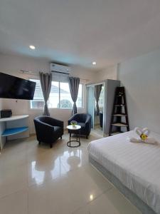 芭东海滩The Villa Residences Resort的一间卧室配有一张床、椅子和电视