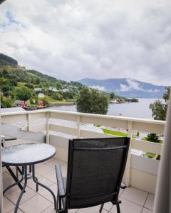 鲁森达尔罗森达尔弗奥德酒店的阳台配有桌椅,享有水景。