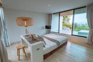 格兰岛Myth Koh Larn resort bar and bistro的一间卧室配有一张床、一张书桌和一个窗户。