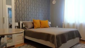 蒂米什瓦拉Crystal Room的一间卧室配有一张带黄色枕头和桌子的床