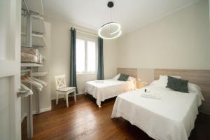 扎马亚Apartamento con garaje en el centro de Zumaia的白色客房 - 带两张床和椅子