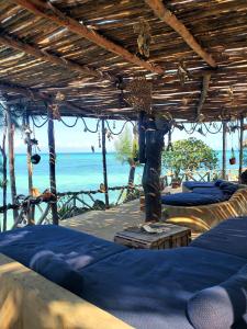 基济姆卡济乐土旅馆的一间设有蓝色床的客房,位于大海的背景中