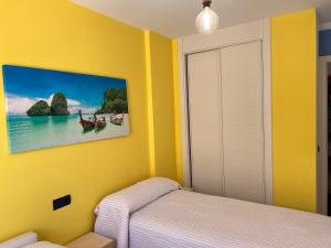拉伊斯莱塔德尔摩洛Isleta 5的黄色的卧室,配有一张床,墙上挂着一幅画