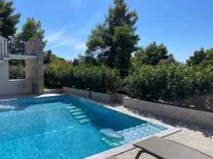 巴尔Villa Pine的后院的游泳池,配有庭院家具和四面 ⁇ 