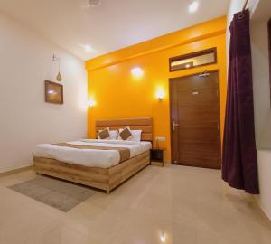 阿格拉The Hideout Agra - Boutique Homestay near Taj的一间卧室配有一张黄色墙壁的床