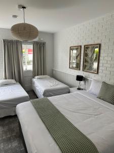 土乌巴三叶草酒店的一间卧室设有三张床和大窗户