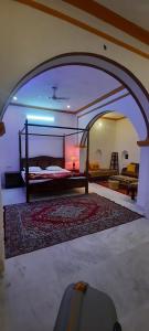 曼达瓦曼达瓦拉迪卡哈维酒店的一间带一张床铺的卧室,位于带拱门的房间