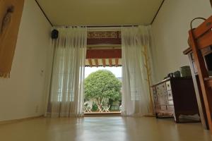 顺天市Daoljae Hanok Pension的一间设有大窗户的客房,窗户上有一棵树