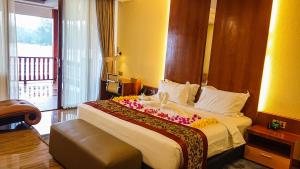 特鲁克巴库Agro Hotel Bintan的酒店客房,配有一张带鲜花的大床
