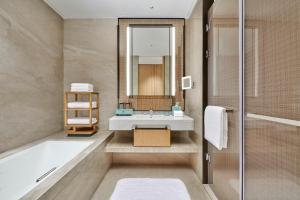 苏州苏州吴中希尔顿逸林酒店的带浴缸、水槽和镜子的浴室