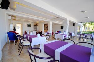 达特恰福达酒店的餐厅配有紫色和白色的桌椅