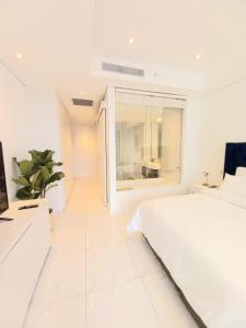 约翰内斯堡Sandton Skye Executive Suite-2的白色的卧室设有白色的床和窗户。