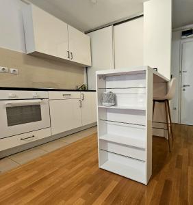 萨格勒布MSS Spot的厨房配有白色橱柜和炉灶烤箱。
