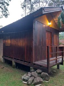甘榜珍德拜Jungle Zen Janda Baik Campsite的小屋设有门廊和长凳。