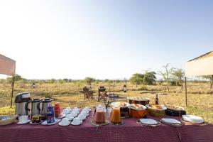 塞伦盖蒂Africa Safari Serengeti Ikoma Camping的一张桌子,上面有食物
