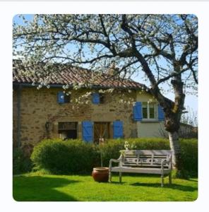 MazièresDomaine Charente - Cottage Charente的石屋前的长凳