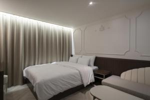 仁川市Incheon Juan Glam的酒店客房,设有两张床和一张沙发