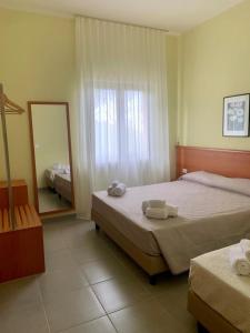 SantʼElia a PianisiPianisi Albergo的酒店客房,设有两张床和镜子