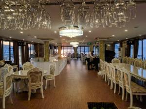 下龙湾La Renta Premium Cruise的用餐室配有桌椅和吊灯。
