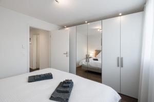MattenSchöne Parterrewohnung in Matten的白色卧室配有床和镜子