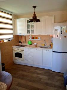 奥赫里德Vila UNIKA的厨房配有白色橱柜和白色冰箱。