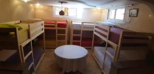 依索安Mubaradise Surf Hostel的客房设有几张双层床和一张桌子。
