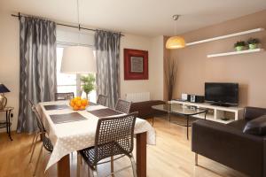 巴塞罗那RAMBLA BEACH Barcelonastuff Apartments的客厅设有餐桌和沙发