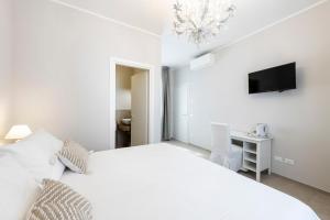 科尔马诺迪伊布拉维B&B酒店的白色卧室配有白色的床和电视