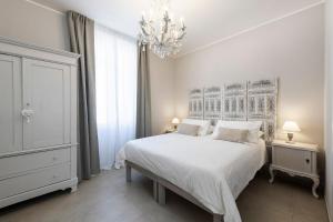 科尔马诺迪伊布拉维B&B酒店的卧室配有白色的床和吊灯。