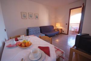 马西亚娜马里纳Residence Il Gabbiano Azzurro的客厅里设有一张桌子,上面放着一碗水果