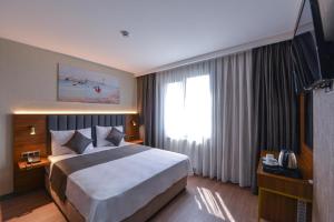 ArnavutköyİSTPORT GARDEN HOTELS的酒店客房设有一张大床和一台电视。