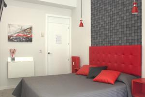 马德里劳里亚旅馆的一间卧室配有一张红色床头板的床