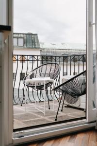 维尔茨堡Appartement Residenz Panorama - Einzigartiges Loft im Herzen von Würzburg mit 2 Balkonen und Panorama-Aussicht!的阳台配有2把椅子和桌子