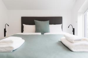 布鲁登茨Neue stylische HÜSLE by UNIQUE PLACES的白色卧室配有一张大床和两条毛巾