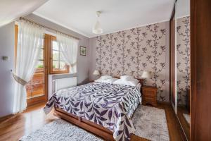 什恰夫尼察Apartamenty u Kukuca的一间卧室配有一张带紫色和白色棉被的床