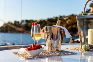 马赛Nuit insolite à bord d'un Yacht的一张桌子,上面放着一杯葡萄酒和一碗草莓