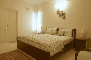 班加罗尔Luxre Homes - Villa in Koramangala的一间卧室设有一张床和一个窗口