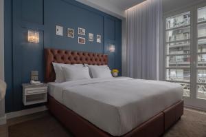 塞萨洛尼基No 39 Svolou Suites的一间卧室设有一张蓝色墙壁的大床