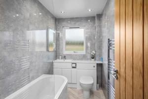 布里金Muirton Cottage的带浴缸、卫生间和盥洗盆的浴室