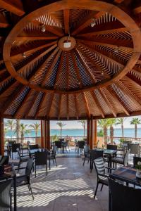 马特鲁港Safir Marsa Matrouh Resort的一间带桌椅和大型木制天花板的餐厅