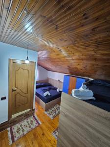 克鲁亚Voga Guesthouse的一间设有两张床和木门的房间