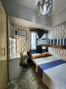 马尼拉High-Tech Studio at Grass Residences -2 persons only, Quezon City的一间卧室设有两张双层床和吊灯。